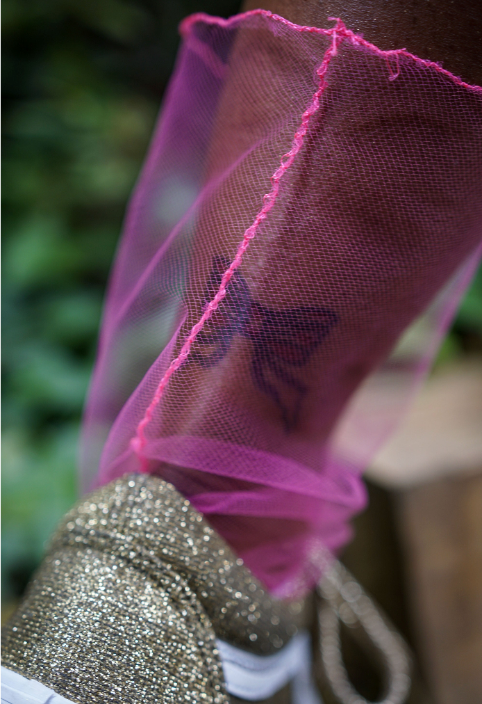 Glittery sneakers with pink sheer socks worn outdoors.